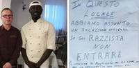 Riccardo Lanzafame con il cuoco del Gambia e il cartello affisso sulla locanda (dal Corriere di Bologna)