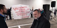 L'arcivescovo Valentinetti davanti allo striscione dei lavoratori di Fraternità magistrale (foto di Giampiero Lattanzio)