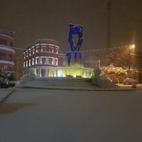 Piazza della Fontana luminosa coperta di neve all'Aquila