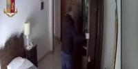 Il ladro-truffatore mentre apre l'armadio nella camera da letto della nonnina