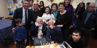 La torta per nonna Nicoletta circondata dai parenti e dal personale della Don Bosco