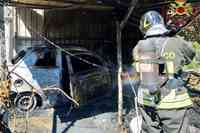 Un vigile del fuoco al lavoro per spegnere le fiamme che hanno divorato un'auto a Manoppello