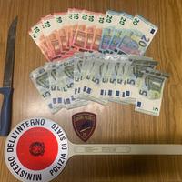 Il coltello e i soldi recuperati dalla polizia dopo la rapina